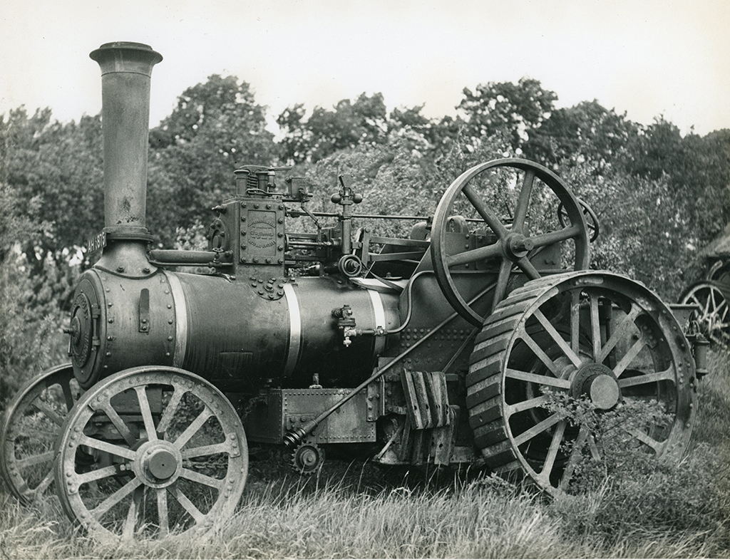 The photograph shows a Burrell 8NHP single cylinder traction engine No. 1602, registered AH 5875, supplied new in 1892. It is shown from the near-side the Flywheel is spoked, the motion gear shows a governor etween the cyliner and flywheel/ Some spuds for the wheels and hanging just ahead of the  rear wheel. 
